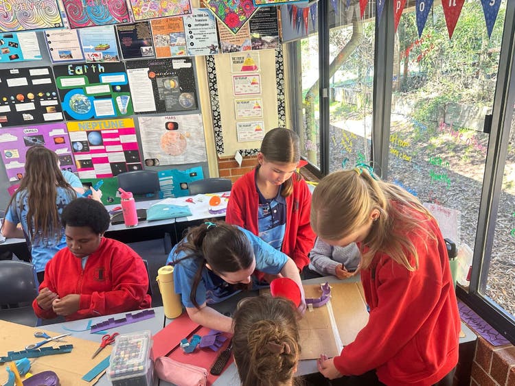 Students in a classroom, creating art and craft.
