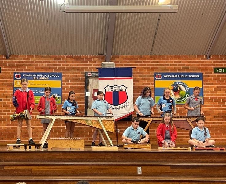 Students performing in the school hall for an assembly.