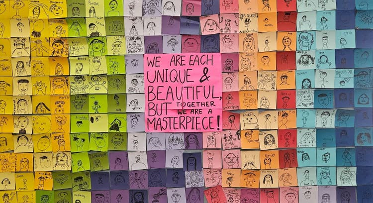 Student artwork composition on the wall in the hall, made up of individual portraits to make a collective image.